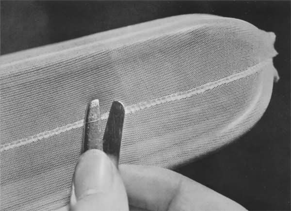 Stray threads in the seam are removed by hand